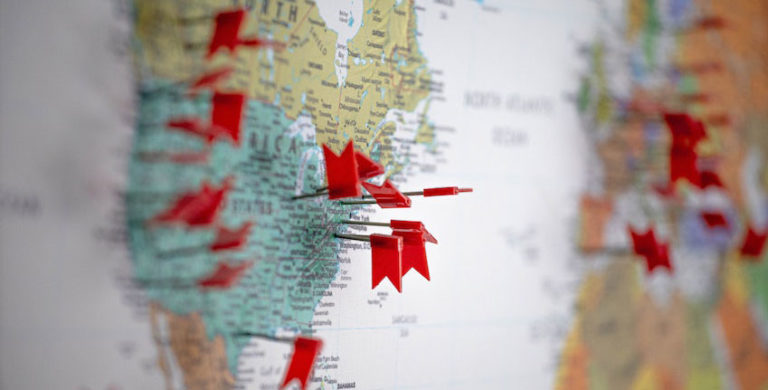 Map of North America with red thumbtacks marking client locations to determine sales territory breakdown