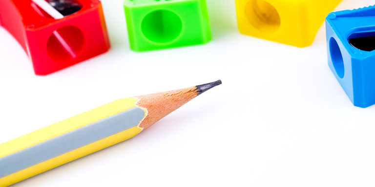 A wooden pencil and 4 different colored manual pencil sharpeners