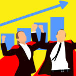 Two people in red capes standing in front of a blue graph showing sales growth