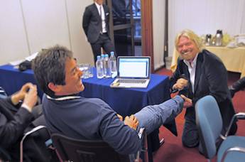 A picture of Richard Branson polishing Guy Kawasaki's shoes