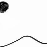 A black telephone with a black cord on a white background