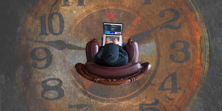 A person sits in a chair on a laptop atop a floor made out of a clock