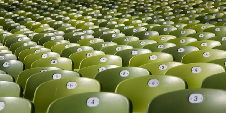 Green stadium chairs with numbers on them.