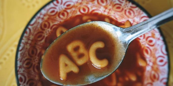 A spoon holds the letter’s ABC from alphabet soup.