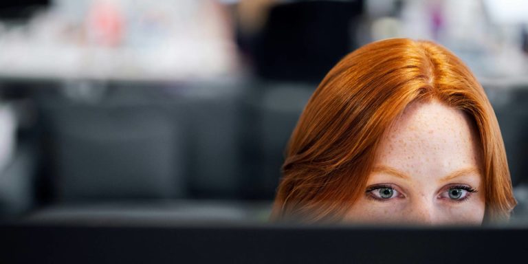 A woman looks at a computer monitor.