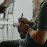 A person takes notes on a notepad.