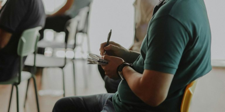 A person takes notes on a notepad.