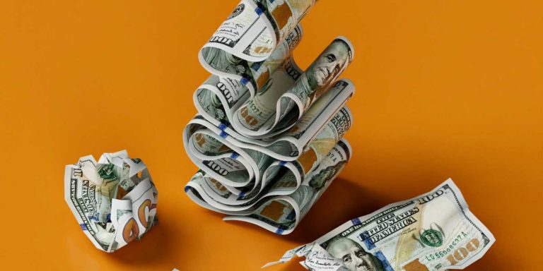 One hundred dollar bills move in a layer and others lay on an orange background.