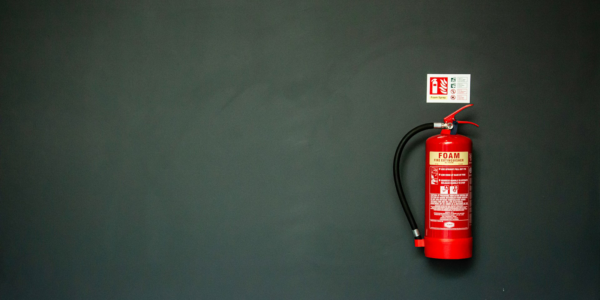 A fire extinguisher on a dark gray wall.
